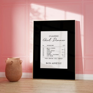 May include: A black framed print with a white background and black text that reads "CLASSIC Girl Dinner" and lists ingredients and quantities for a meal. The text includes "Mac n Cheese", "Wine", "Pizza Rolls", "Popcorn", "Salami", "Cherries & Crackers", and "Ice Cream". The print also includes the text "BON APP&Eacute;TIT".