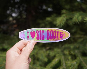 Op de afbeelding: Een kleurrijke sticker in de vorm van een surfplank met de tekst "I ❤️ BIG BOOFS" in een psychedelisch lettertype. De sticker heeft een hartsymbool en een gradiënt achtergrond van roze, geel en groen.