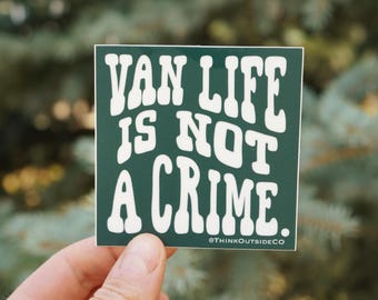 Op de afbeelding: Een vierkante sticker met een donkergroene achtergrond en witte tekst die VAN LIFE IS NOT A CRIME luidt. De tekst is in een vet, golvend lettertype. In de rechterbenedenhoek staat kleinere witte tekst met @THINKOUTSIDECO.
