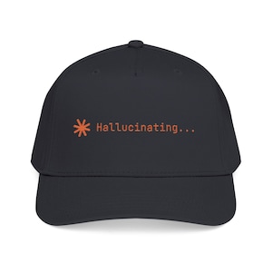 May include: A dark navy baseball cap with a curved peak. The cap displays the word "Hallucinating..." in orange, accompanied by an orange asterisk symbol. The hat is made of a soft material and has a structured fit.