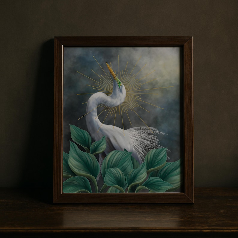 Pode incluir: Uma impress&atilde;o de arte emoldurada apresentando uma gar&ccedil;a branca com um pesco&ccedil;o longo e curvo, posicionada atr&aacute;s de grandes folhas verdes. A ave tem um bico amarelo e um design de halo dourado radiante saindo da cabe&ccedil;a num fundo escuro.