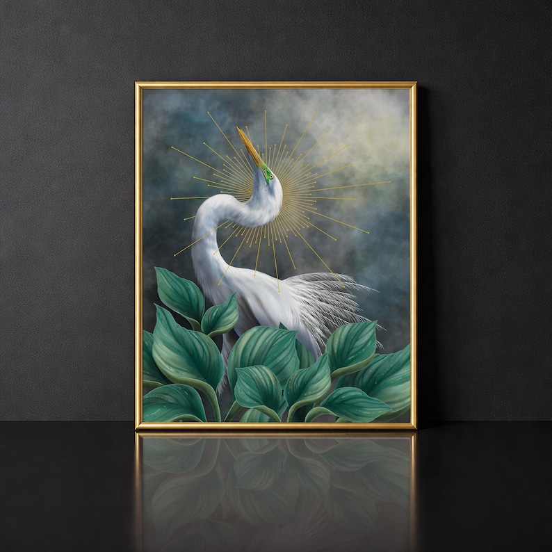 Pode incluir: Uma impress&atilde;o de arte de parede emoldurada apresentando uma gar&ccedil;a branca com um pesco&ccedil;o longo e curvo, posicionada atr&aacute;s de grandes folhas verdes. Um halo dourado de raios de sol irradia atr&aacute;s da cabe&ccedil;a da ave contra um c&eacute;u escuro e nublado.