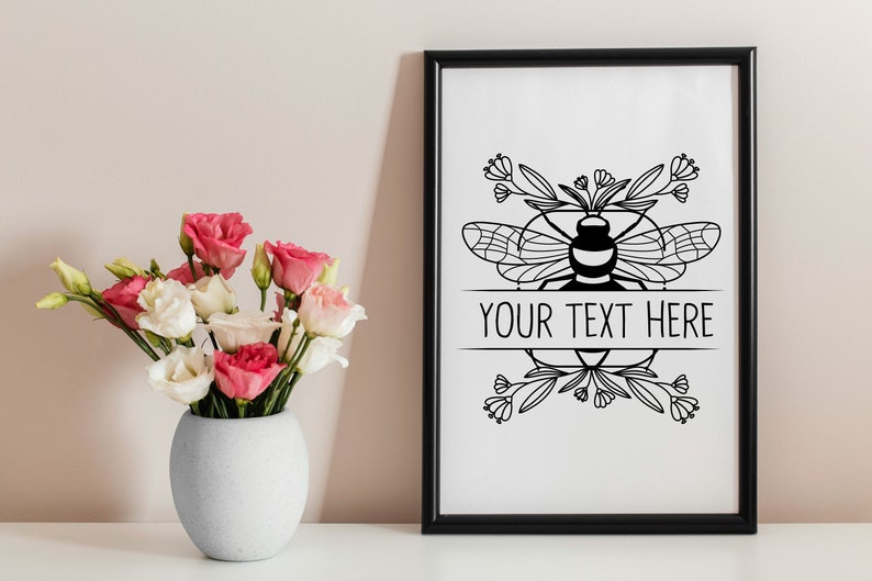 May include: Black and white printable art print featuring a bee with floral accents and the text "YOUR TEXT HERE".