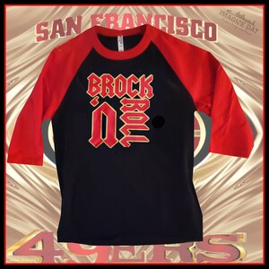 Brock Purdy &#39;BROCK N ROLL&#39; Camiseta de béisbol negra/roja (Unisex)