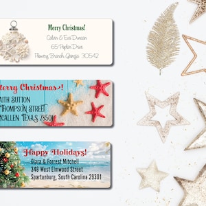 May include: Three Christmas gift tags with festive designs. The first tag features a seashell ornament with the text "Merry Christmas!" and an address. The second tag features a beach scene with starfish and the text "Merry Christmas!" and an address. The third tag features a Christmas tree with ornaments and the text "Happy Holidays!" and an address.