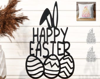 Könnte beinhalten: Schwarze Osterdekoration mit dem Text "HAPPY EASTER", Hasenohren und drei verzierten Eiern. Die Dekoration ist auf einem Holzsockel montiert. Ein Kissen und zwei kleinere Dateien sind ebenfalls abgebildet.
