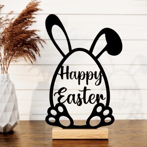 May include: Black wooden cutout of a bunny rabbit holding an egg that says "Happy Easter".