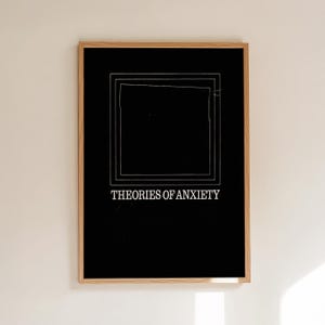 May include: A framed art print with a black background and white text that reads "THEORIES OF ANXIETY." The artwork features a series of nested white squares. The frame is made of light-colored wood.