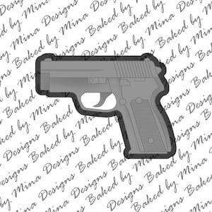 Peut inclure: Une découpe en plastique gris d'une arme à feu. La découpe est un motif populaire pour la décoration de gâteaux.