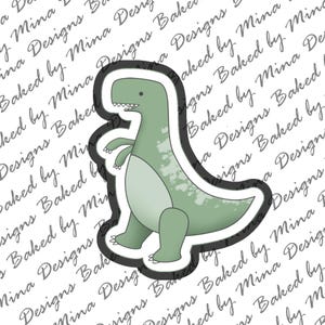 May include: A green dinosaur cookie cutter with a white outline. The dinosaur is standing on all fours with its mouth open.