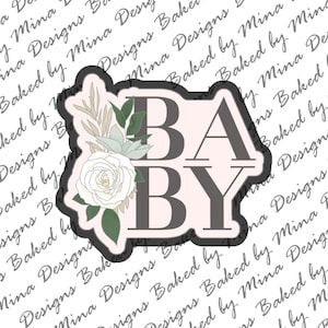 May include: A pink and gray 'BABY' sign with a white rose and green leaves.