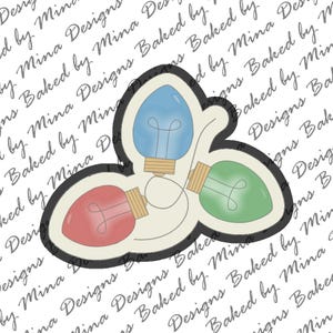 Op de afbeelding: Drie kerstverlichting in de vorm van een traan, met rode, blauwe en groene lampen. De lampen zijn verbonden door een wit snoer.