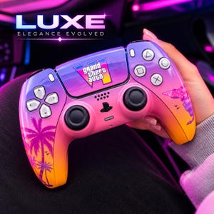 Könnte beinhalten: Ein kabelloser Videospiel-Controller mit einem Farbverlauf in Violett, Pink und Orange. Das zentrale Touchpad zeigt das Grand Theft Auto VI-Logo. Der Controller ist mit Palmensilhouetten, einer Kartenumrisslinie und Standardtasten versehen.