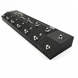 May include: A black Boss ES-8 Effects Switching System with eight footswitches and a digital display. The footswitches are labeled 1 through 8, and the display shows "BANK 7" and "BANK 4".