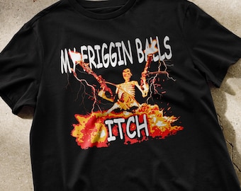 May include: Black t-shirt with a graphic print of a skeleton holding two guns with flames and the text "My Frigging Balls Itch".