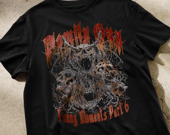 May include: Black t-shirt with a graphic print of a skull with a red and orange design. The text "Funny Moments Part 6" is printed below the skull.
