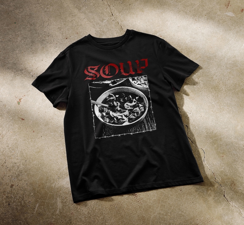 May include: Black t-shirt with a white graphic of a bowl of soup and the word "SOUP" in red lettering.