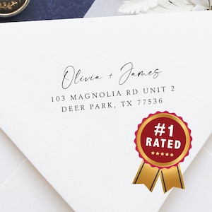 May include: White envelope with a return address label that reads "Olivia + James 103 Magnolia Rd Unit 2 Deer Park, TX 77536". A gold and red #1 Rated sticker with five stars is on the right side of the envelope.