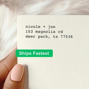 May include: A cream-colored rectangular card featuring black typewriter-style text that reads: nicole + jon, 103 magnolia rd, deer park, tx 77536. The card has a smooth, matte texture and is presented with clean, sharp edges and a minimalist layout.