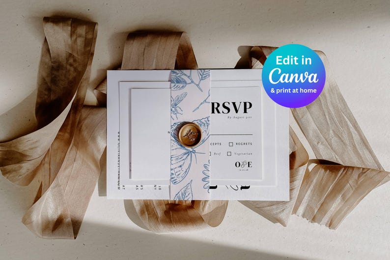 photo of the entire bundle of wedding stationery wrapped in a blue toile belly band with a gold wax seal
