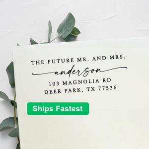 May include: A rectangular white card featuring black printed text that reads THE FUTURE MR. AND MRS. and anderson in a cursive script, followed by the address 103 MAGNOLIA RD, DEER PARK, TX 77536. The card is accented by green eucalyptus leaves.