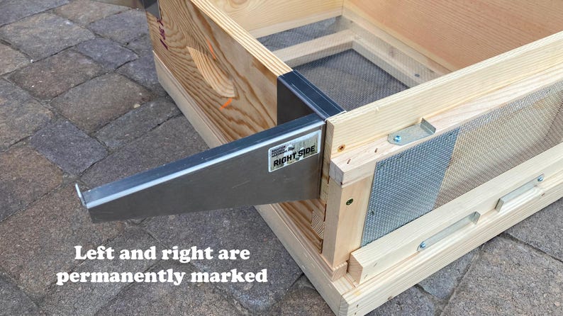 Op de afbeelding: Een houten bijenkorf met een metalen frame en een gaas. Het frame is gemarkeerd met "Right Side".