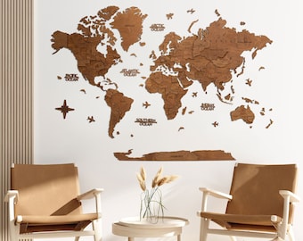 May include: A wooden world map with the names of the oceans labeled. The map is mounted on a white wall in a room with two brown leather chairs and a small round table with a vase of dried flowers.