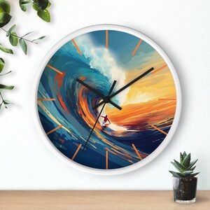 May include: White wall clock with a colorful image of a surfer riding a large wave. The wave is blue, green, and orange with a sunset in the background.