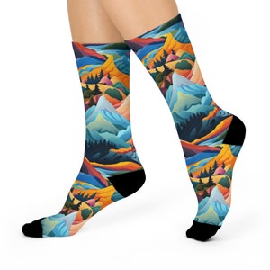 May include: Colourful socks with a mountain landscape design. The socks feature a blue, green, yellow, and orange colour scheme with a repeating pattern of mountains, trees, and sky.