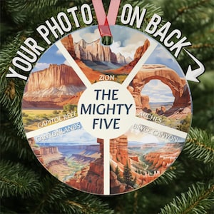 May include: A round, white ornament with a picture of the Mighty Five National Parks: Zion, Arches, Bryce Canyon, Canyonlands, and Capitol Reef. The ornament has the words "The Mighty Five" in the center.