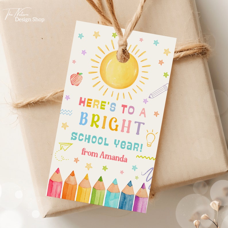 May include: A colorful gift tag with a sun, stars, pencils, and the text "Here's to a bright school year! from Amanda".
