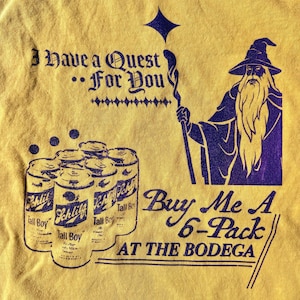 May include: A yellow t-shirt with a purple graphic of a wizard holding a staff and a six-pack of beer. The text on the shirt reads "I have a quest... for you" and "Buy me a 6-pack at the bodega."