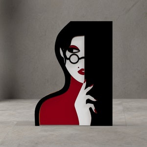May include: A stylized art piece featuring a woman's face in black, white, and red. The woman wears round glasses and has red lipstick and nails. The artwork is a modern, minimalist design, suitable for home decor.