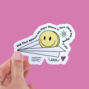 Waterdichte papieren vliegtuig humoristische sticker | "Vouw hun meningen in papieren vliegtuigjes en verander ze in Flying F*cks"