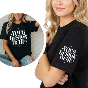 Puede incluir: Una camiseta negra de manga corta con el texto blanco "YOUR DESIGN HERE" en una fuente ondulada de estilo retro. El diseño está decorado con pequeños corazones blancos y estrellas de cuatro puntas, situados en el pecho y en la manga.