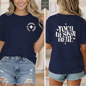 May include: A navy blue t-shirt featuring a white circular graphic with a four-pointed star on the front left chest and a large white wavy text graphic on the back that reads YOUR DESIGN HERE, accented with small hearts and star symbols.