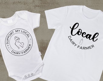 May include: White baby onesie with the text "I support my local dairy farmer" in a circle with a breastfeeding mother and a milk bottle graphic. White t-shirt with the text "local dairy farmer" in cursive with a milk bottle graphic.
