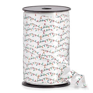 May include: A roll of white ribbon with a repeating pattern of colorful Christmas lights. The ribbon is on a black spool, and a length of ribbon is unrolled, showing the design. The lights are red, green, blue, and yellow.