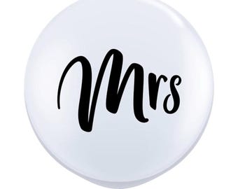 May include: White balloon with the word "Mrs." printed in black cursive lettering.