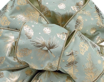 Puede incluir: Primer plano de una cinta decorativa con un fondo verde claro y un diseño dorado de piñas y agujas de pino. La cinta tiene un ribete dorado en los bordes, creando un aspecto festivo y elegante. Ideal para decoraciones navideñas.