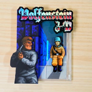 May include: A Wolfenstein 3-D video game cartridge with a colorful graphic of a character holding a gun, and a soldier in a doorway. The game title is in a blue and red font.
