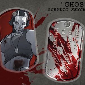 Puede incluir: Llavero acrílico con una ilustración estilizada de un personaje con rostro de calavera, que lleva auriculares y vestimenta de estilo militar. El diseño del llavero incluye una chapa de identificación con el nombre "Riley Simon 'Ghost'" y salpicaduras de sangre. El texto "Ghost" está en la parte superior.