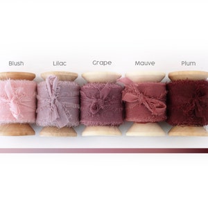 Peut inclure: Cinq bobines de ruban d&eacute;coratif dans des tons de rose et de violet. Chaque bobine est &eacute;tiquet&eacute;e avec un nom de couleur : Blush, Lilac, Grape, Mauve et Plum. Le ruban a un bord effiloch&eacute; et est nou&eacute; en un n&oelig;ud.