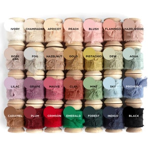 silk ribbons on spools lined up in four rows of seven colors each, from light to dark