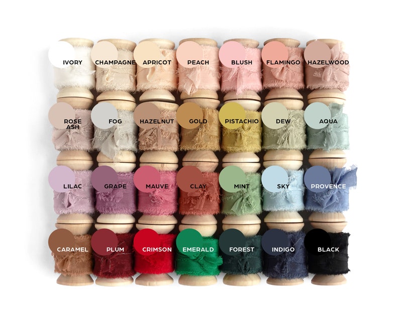 silk ribbons on spools lined up in four rows of seven colors each, from light to dark