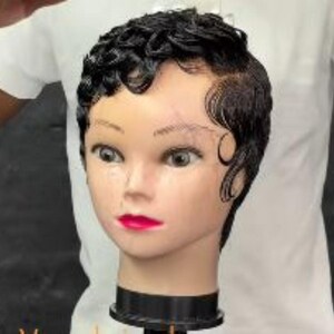 May include: A mannequin head with dark, styled hair and bright red lipstick. The hair is styled in a classic, vintage finger wave pattern. The mannequin has a neutral skin tone and is mounted on a black base.