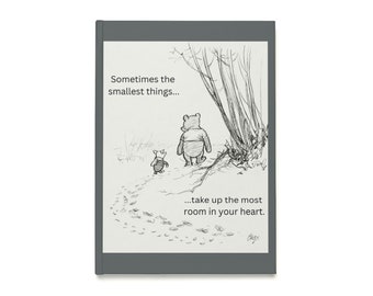 May include: A grey journal with a black and white illustration of Winnie the Pooh and Piglet. The text says, "Sometimes the smallest things...take up the most room in your heart."