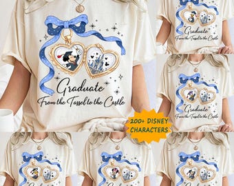 May include: Cream-colored t-shirt featuring a heart-shaped pendant design with Disney characters and the text "Graduate From the Tassel to the Castle." The pendant is adorned with a blue bow and ribbon. The shirt also has the text "200+ DISNEY CHARACTERS."
