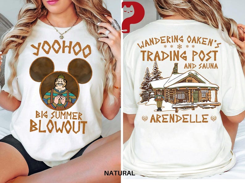 May include: Cream-colored t-shirt with a front graphic featuring a cartoon character within Mickey Mouse ears and text that reads "Yoohoo Big Summer Blowout." The back of the shirt displays "Wandering Oaken's Trading Post and Sauna" with a cabin illustration.