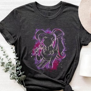 May include: A dark grey t-shirt with a purple and pink silhouette of a woman with long hair holding a flower. The woman is surrounded by a purple and pink nebula.